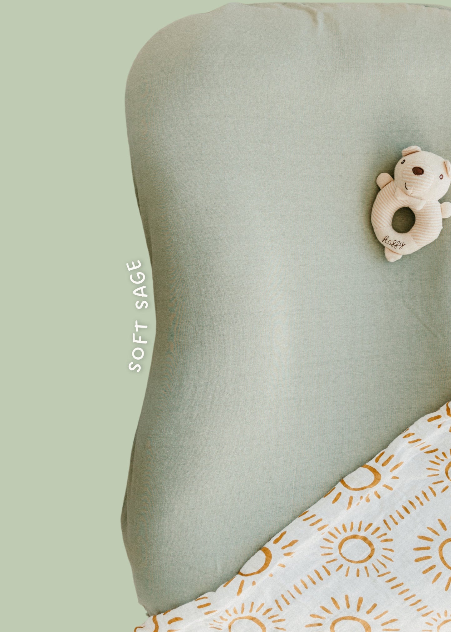 Green pillow with a soft toy and white blanket with yellow sun pattern on a light green background